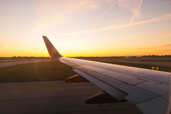 Sunrise over airplane wing